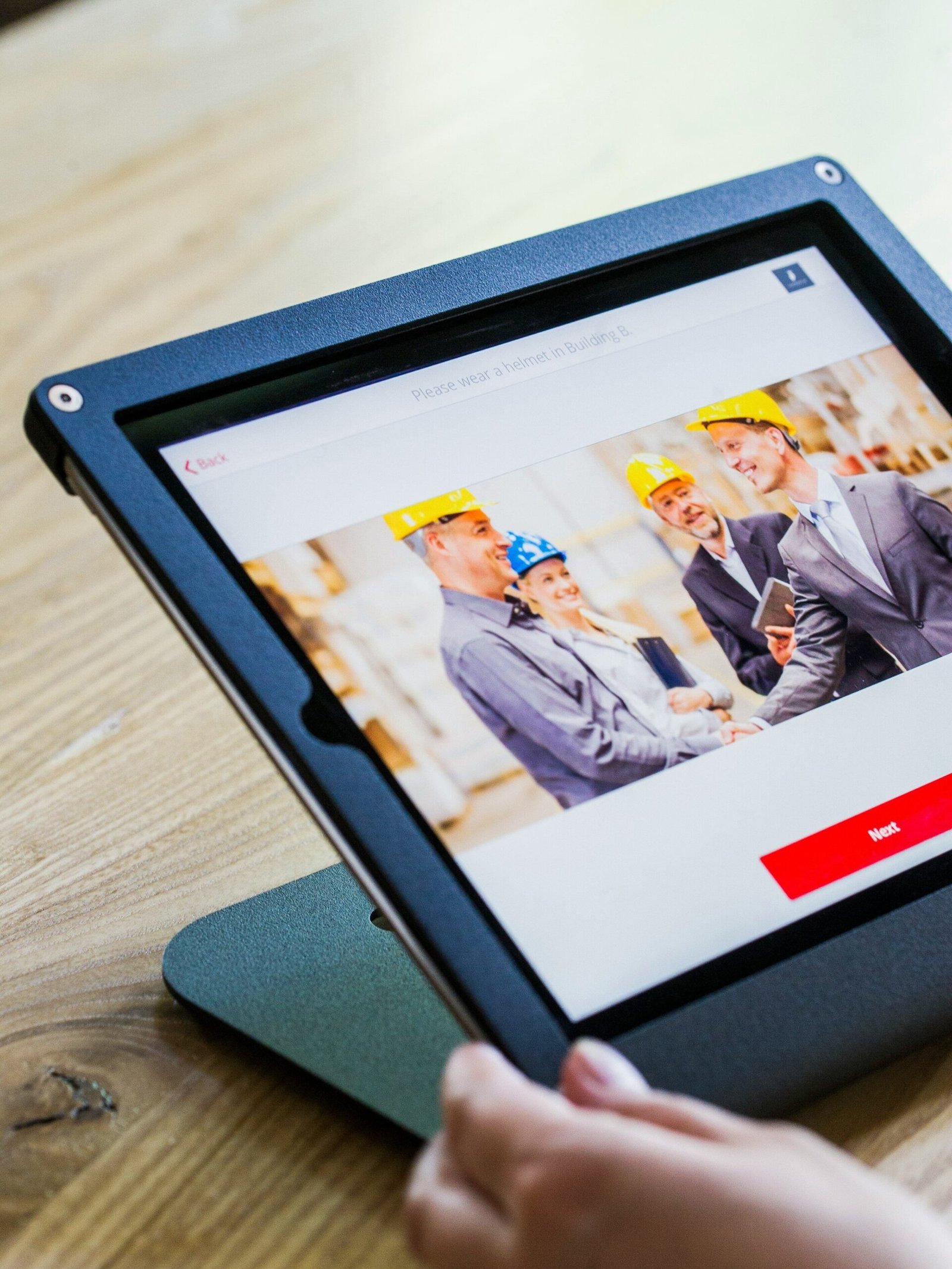 iPad with four business persons shaking hands display